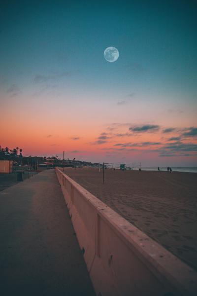 一轮圆月挂在沙滩上空
